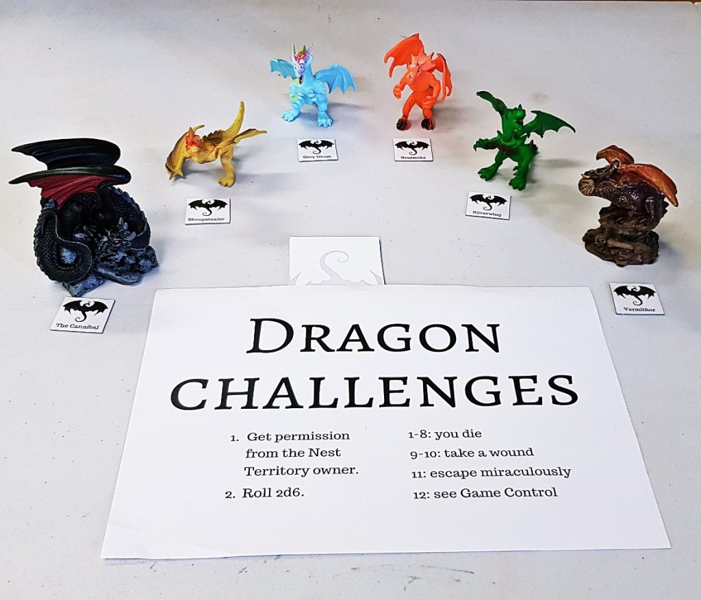 A board reading "Dragon Challenges" with the rules below, surrounded by multiple dragon figurines of different sizes
