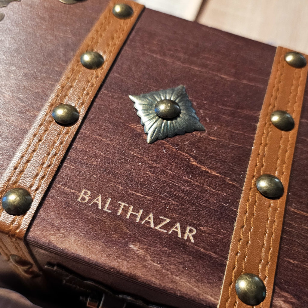 The word "Balthazar" etched into a wooden box